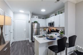 Atlanta apartment for rent - an open kitchen and dining area with stainless steel appliances and white cabinets