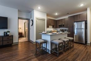 Indian Trail apartment for rent - A kitchen with a bar stool and a refrigerator.
