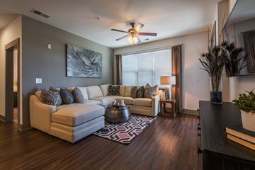 Indian Trail apartment for rent - A living room with a white couch and a ceiling fan.