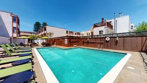 San Francisco apartment for rent - a swimming pool with chaise lounge chairs and umbrellas in front of a building