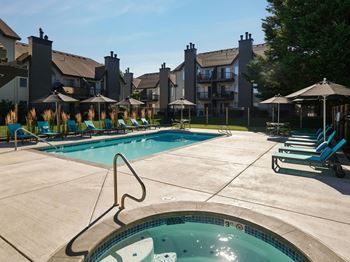 Swimming pool area with relaxing loungers, spa, & bbq area