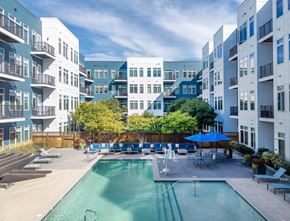 Medford apartment for rent - A swimming pool in the middle of a courtyard surrounded by buildings.