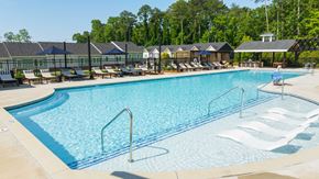 Mcdonough apartment for rent - A large swimming pool with a metal ladder and sun loungers.