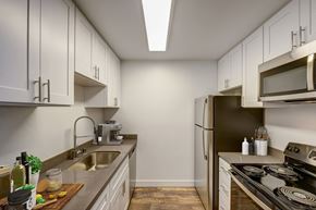 Santa Cruz apartment for rent - a kitchen with white cabinets and a stainless steel refrigerator