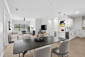 Chamblee apartment for rent - A modern dining room with a black table and grey chairs.