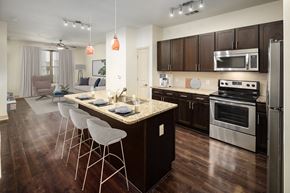Brookhaven apartment for rent - a kitchen with a center island with stools and a living room with a couch
