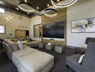 Lebanon apartment for rent - A modern living room with a large couch, a television, and a painting on the wall.