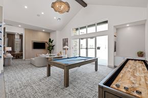 Denton apartment for rent - A billiard table is in the middle of a room with a television, couches, and a pool table.