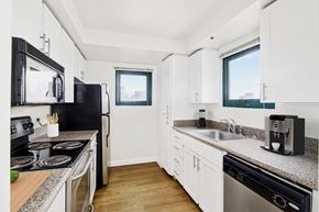 San Francisco apartment for rent - a kitchen with granite counter tops and black appliances and white cabinets