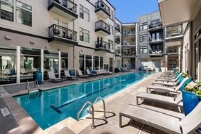 Austin apartment for rent - A swimming pool surrounded by lounge chairs and buildings.