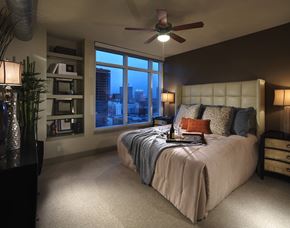 Los Angeles apartment for rent - A bedroom with a large bed and a window overlooking the city.