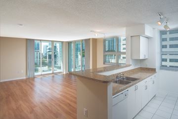 Miami apartment for rent - A kitchen with white cabinets and a wooden floor.