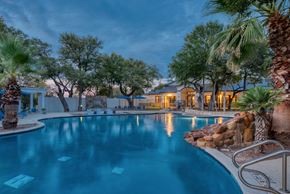 San Antonio apartment for rent - a large swimming pool with a house in the background