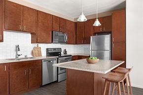 Kapolei apartment for rent - a kitchen with stainless steel appliances and wooden cabinets