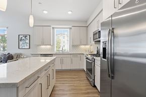 San Diego apartment for rent - A modern kitchen with a stainless steel refrigerator and wooden floors.