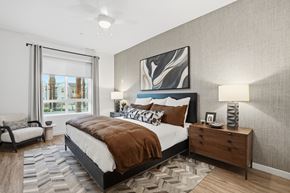 Chula Vista apartment for rent - A bedroom with a large bed, a nightstand, and a painting on the wall.