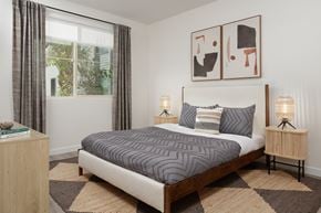 Anaheim apartment for rent - A bedroom with a large bed and two lamps.
