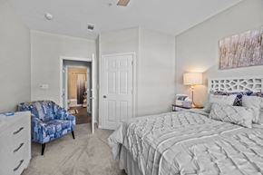 Charlotte apartment for rent - a bedroom with a bed and a chair and a closet