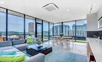 Modern living room with a view of the cityscape outside the large windows.