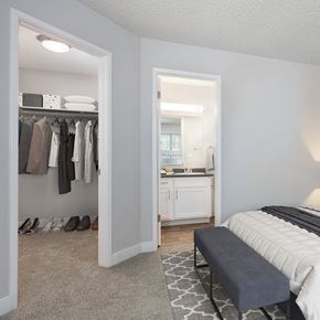Livermore apartment for rent - A bedroom with a view into the entry of the bathroom and a view of a spacious closet with well organized clothing and shoes.
