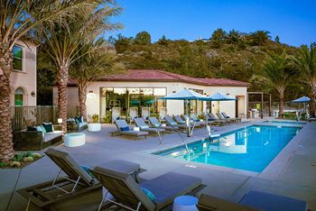 A resort style pool with lounge chairs and umbrellas