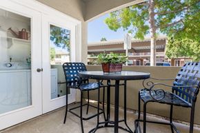San Diego apartment for rent - A patio with a table and chairs and a view of a building.