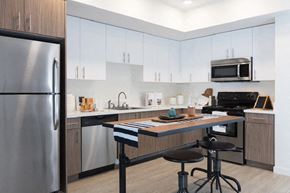 San Jose apartment for rent - A modern kitchen with a stainless steel refrigerator and a wooden island.