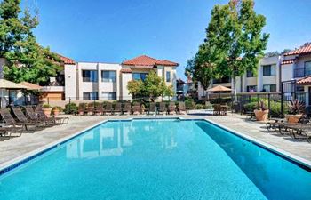 A swimming pool in front of apartment buildings.