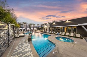 Las Vegas apartment for rent - a resort style swimming pool with chaise lounge chairs and a building in the background