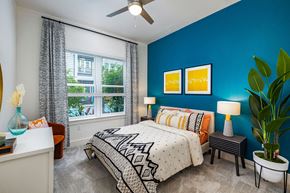 Tampa apartment for rent - a bedroom with a blue wall and a white ceiling fan