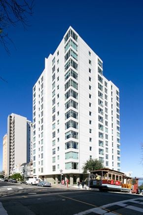 San Francisco apartment for rent - a view from the street of a large white building with a trolley in front of it