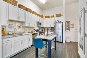 Stamford apartment for rent - a kitchen with white cabinets and a blue table