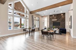 Prosper apartment for rent - the gathering place at gardner village resident lounge with tables and chairs and large windows