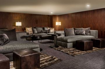 Houston apartment for rent - A living room with a grey couch and a brown ottoman.