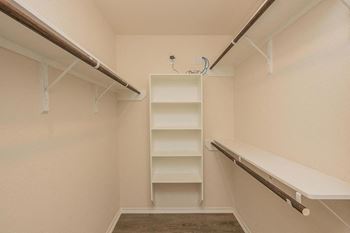 Spacious walk-in closet with a rack of empty shelves