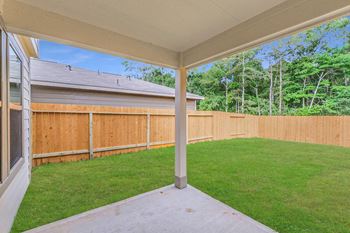 A backyard with a wooden fence and a patio