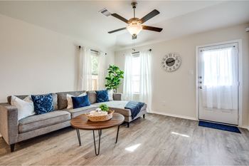 A living room with a ceiling fan and a couch