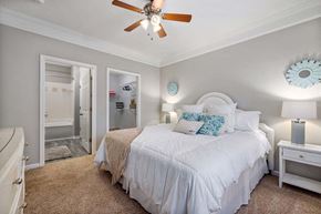Raleigh apartment for rent - a bedroom with a large bed and a ceiling fan
