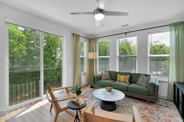 Charlotte apartment for rent - a living room with a green couch and a ceiling fan