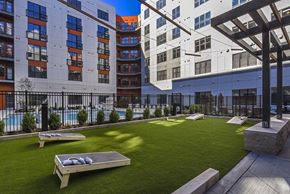 Baltimore apartment for rent - an outdoor lounge area with grass and a pool in front of buildings