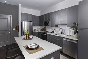 Baltimore apartment for rent - a kitchen with stainless steel appliances and gray cabinets