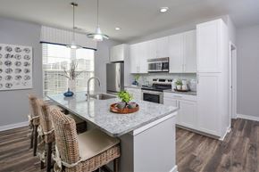 Ellicott City apartment for rent - a kitchen with white cabinets and a marble counter top
