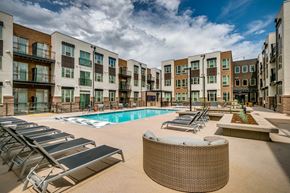 Lakewood apartment for rent - an outdoor pool with lounge chairs at an apartment building