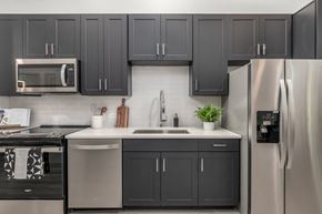 Lakewood apartment for rent - a kitchen with black and white cabinets and stainless steel appliances