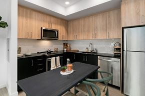 Gresham apartment for rent - a kitchen with wooden cabinets and stainless steel appliances and a black table