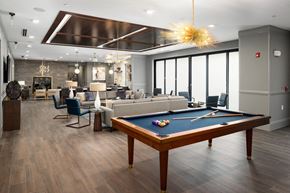 Brookhaven apartment for rent - a community room with a pool table and couches and a living room with windows