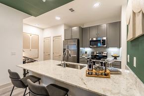 Conroe apartment for rent - a kitchen with a marble counter top and stainless steel appliances