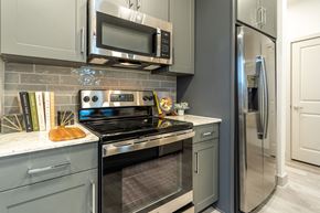 Katy apartment for rent - a kitchen with stainless steel appliances and white cabinets