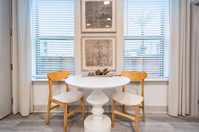 Katy apartment for rent - a dining room with a table and chairs and two windows