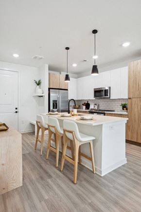 Nashville apartment for rent - a kitchen with white cabinets and a large island with chairs at Alta City Side, Nashville, TN